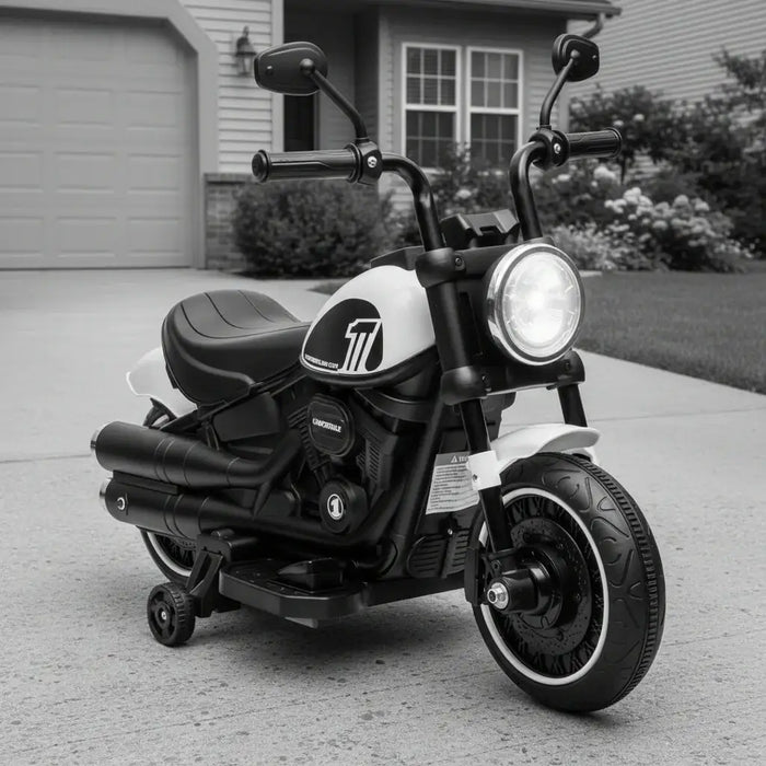 Black and white kids electric motorcycle with training wheels parked on driveway in front of house