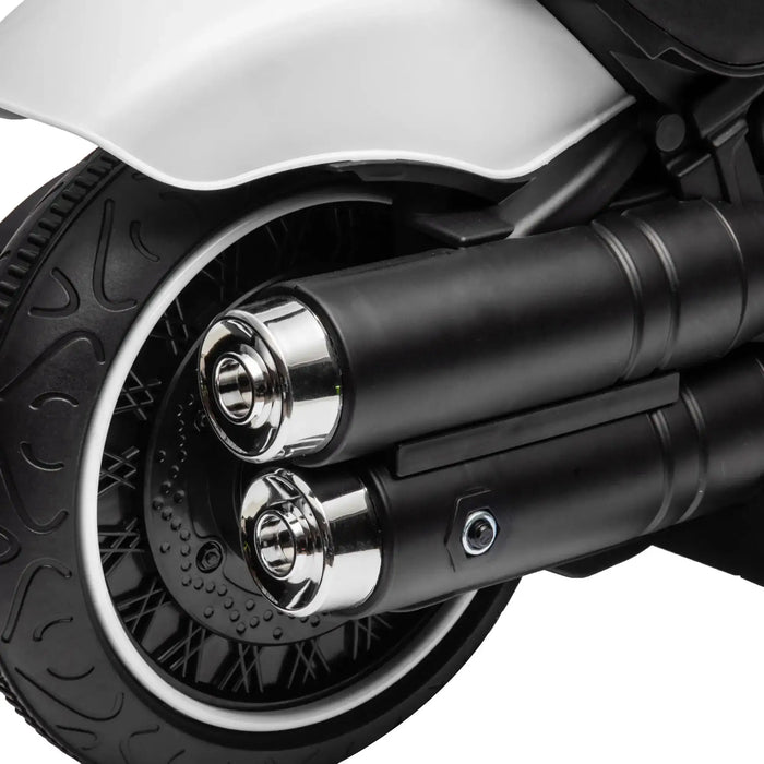 Close-up of a black motorcycle rear wheel with dual chrome exhaust pipes and white fender