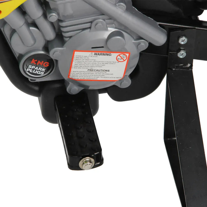 Close-up of 6V kids electric ride-on motorbike pedal, engine details, and warning label