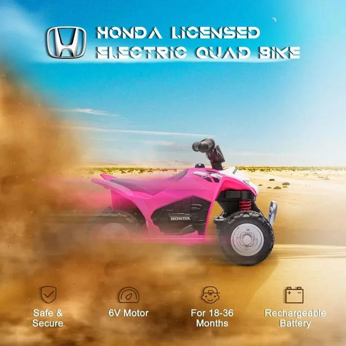 Pink Honda licensed kids electric quad bike rides in sandy desert with dust and blue sky.