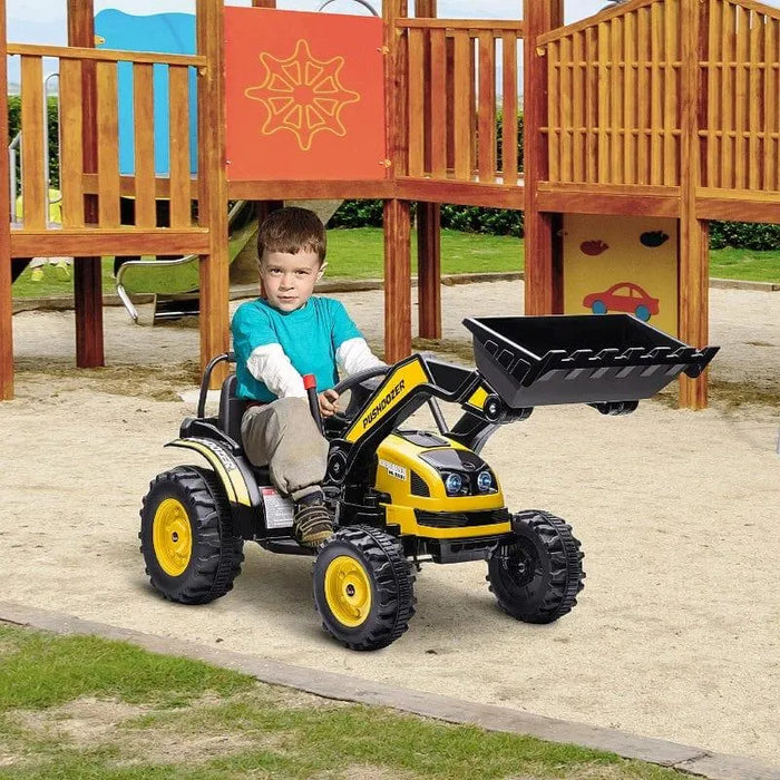 Child riding a yellow kids ride-on bulldozer with working shovel at playground