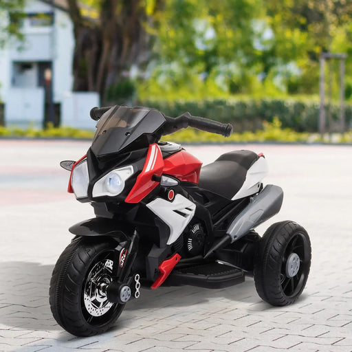 Children's toy motorcycle with red and black accents on a paved surface.
