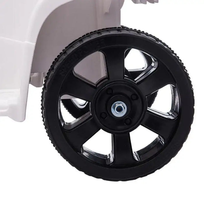Close-up of black plastic ATV wheel on white 6V kids ride-on quad bike