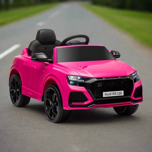 Pink Audi RS Q8 kids electric ride on car with black wheels on outdoor road