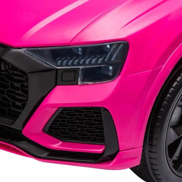 Close-up of pink kids electric ride-on Audi RS Q8 car front headlight and grill