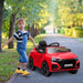 Child in overalls with red Audi RS Q8 kids ride-on car on a tree-lined outdoor path