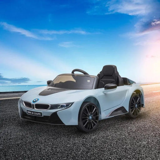 Blue BMW i8 Coupe kids electric ride-on car with two opening doors on an outdoor road