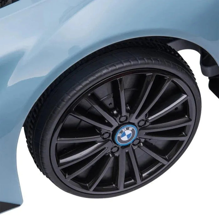 Close-up of black BMW i8 coupe kids electric ride-on car wheel against blue body