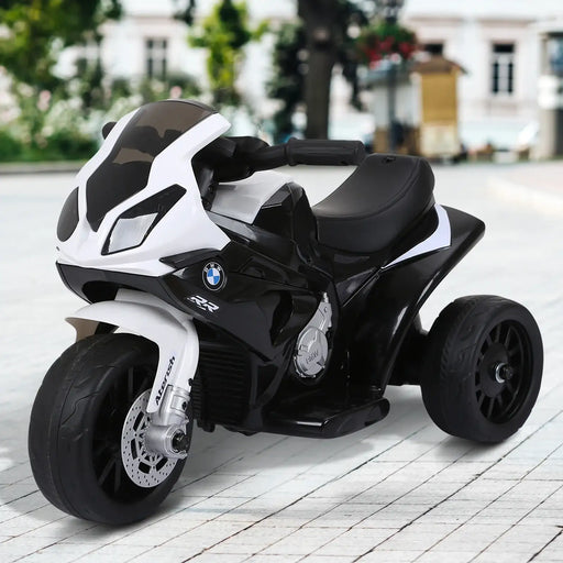 Black and white BMW kids electric motorbike with realistic lights on paved outdoor area