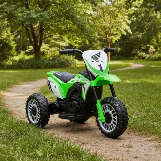 Green Honda kids electric ride-on motorbike on a dirt path in a park