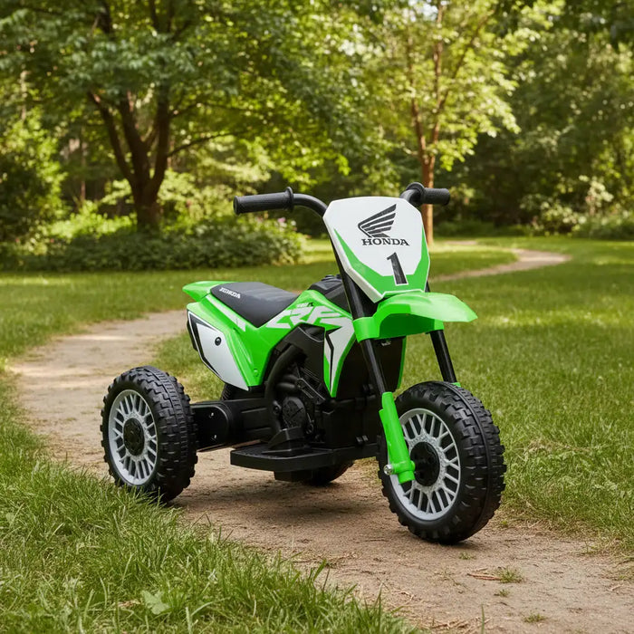 Green Honda kids electric ride-on motorbike on a dirt path in a park