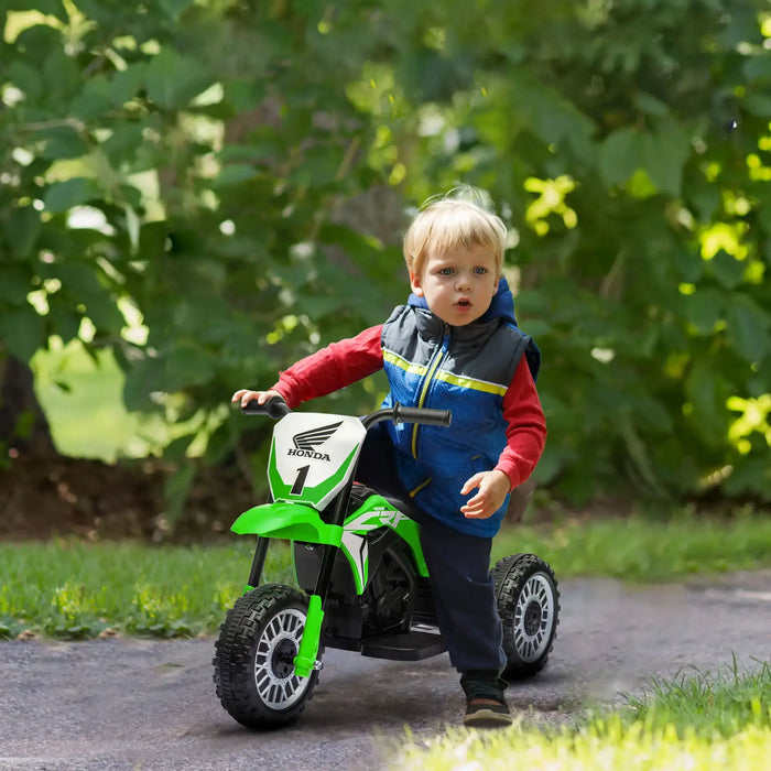 Young child outdoors on green Honda CRF450RL kids electric ride-on motorbike toy