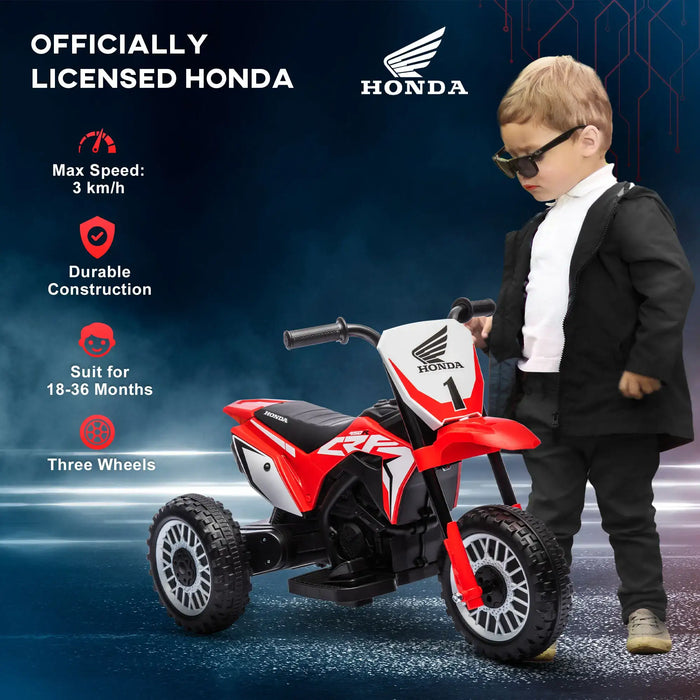 Child in black outfit stands by red Honda kids electric ride-on motorbike with three wheels