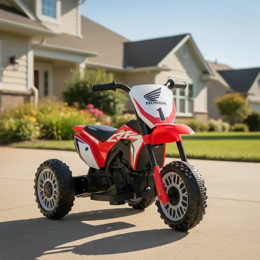 Red Honda kids electric ride-on motorbike on driveway in suburban neighborhood