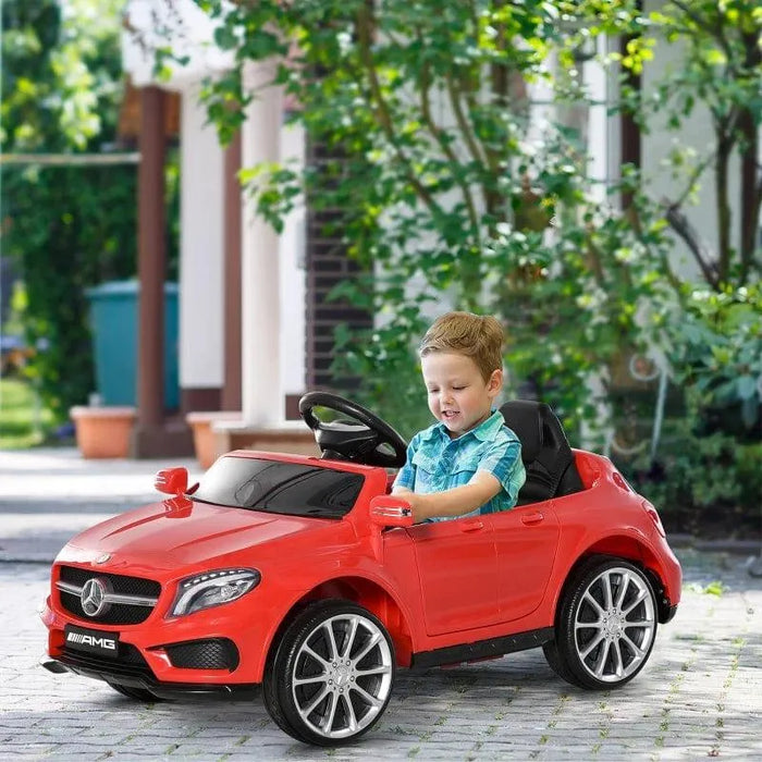 Boy riding red Mercedes AMG kids electric ride-on car outdoors