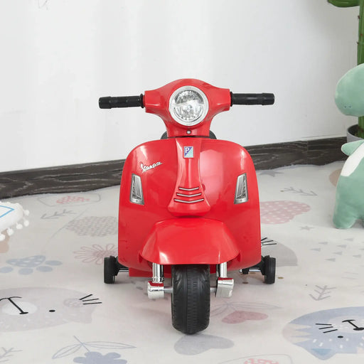 Red Vespa kids electric ride-on motorbike with stabilisers on playroom floor