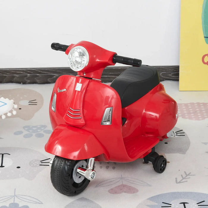 Red Vespa kids electric ride-on motorbike with stabilisers on playroom rug