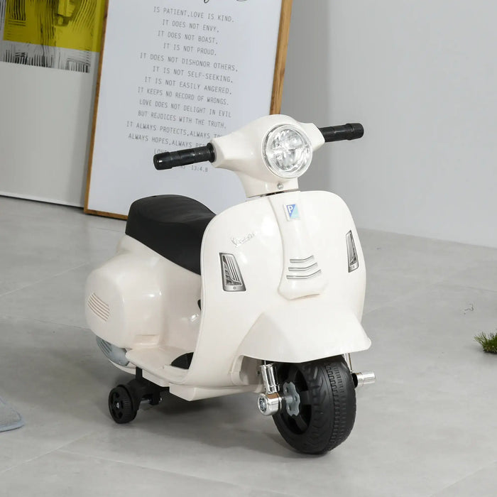 White Vespa kids electric ride-on motorcycle with training wheels indoors