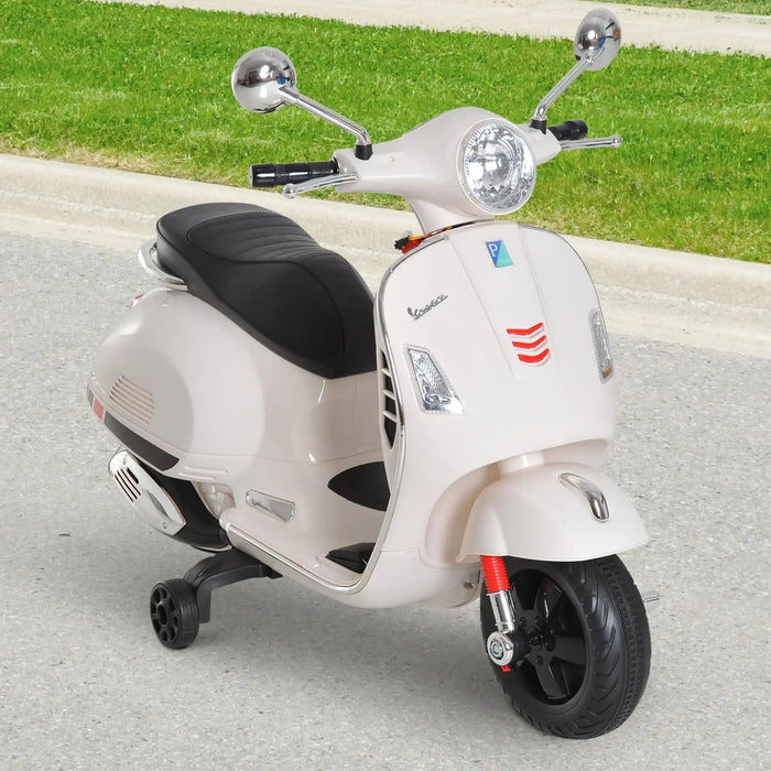 White Vespa scooter with black seat and chrome mirrors parked on pavement near green grass