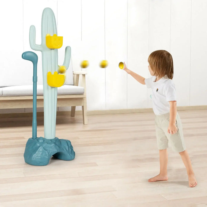 Child playing with a cactus-shaped toy that shoots balls indoors.