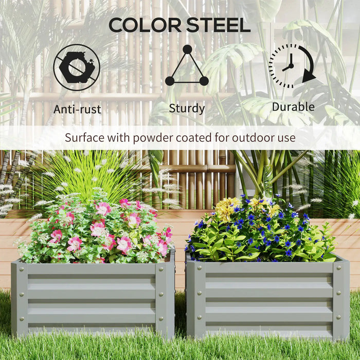 Two gray powder-coated steel garden planters with pink and blue flowers in a sunny backyard garden