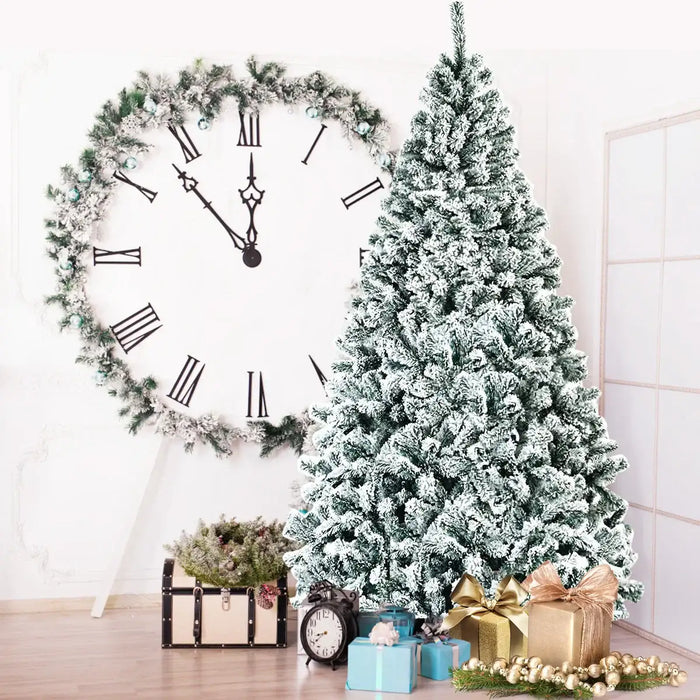 Frosted Christmas tree with decorative items in a room with a large clock.