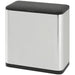 Stainless steel trash can with black lid on a white background