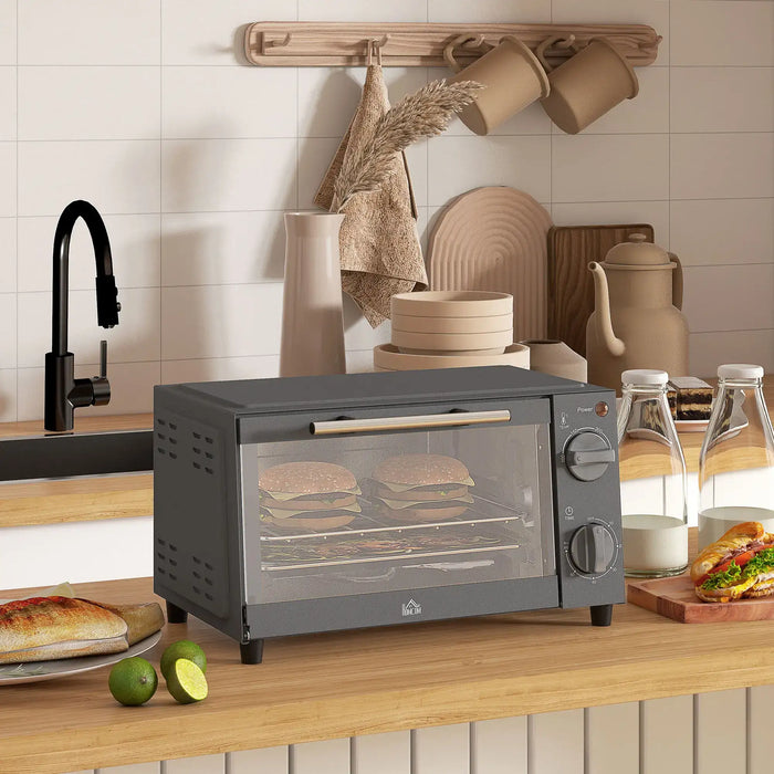 Gray toaster oven on a kitchen counter with sandwiches inside, surrounded by kitchen items.