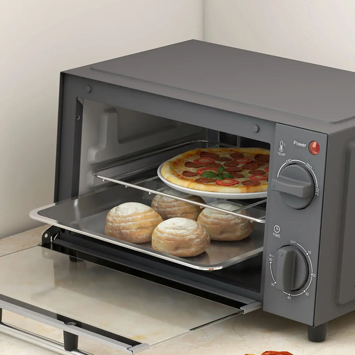 Gray toaster oven with pizza and bread inside on a light-colored surface.
