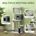 Gray multi-level cat tree with condo, perch, and bed for cats in a green room
