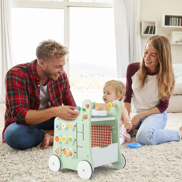 Family playing with a toy shopping cart on a carpeted floor.