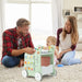 Family playing with a toy shopping cart on a carpeted floor.