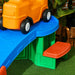 Toy truck on a blue ramp with green and red base, outdoor setting