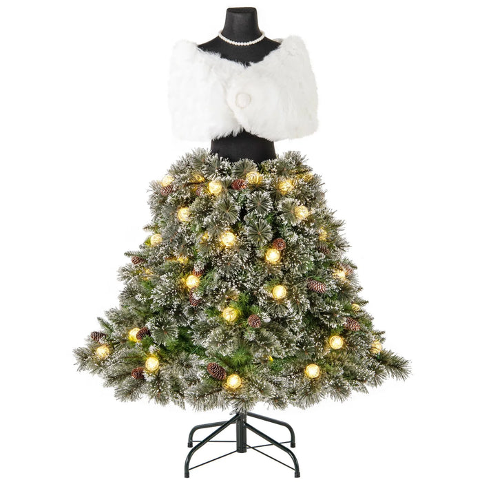 Christmas tree skirt with snow-frosted pine branches, pine cones, and warm white lights on mannequin