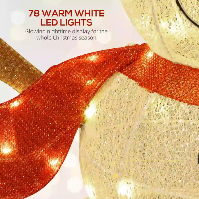 Close-up of a glittery white Christmas decoration wrapped with a red glitter scarf and warm white LED lights