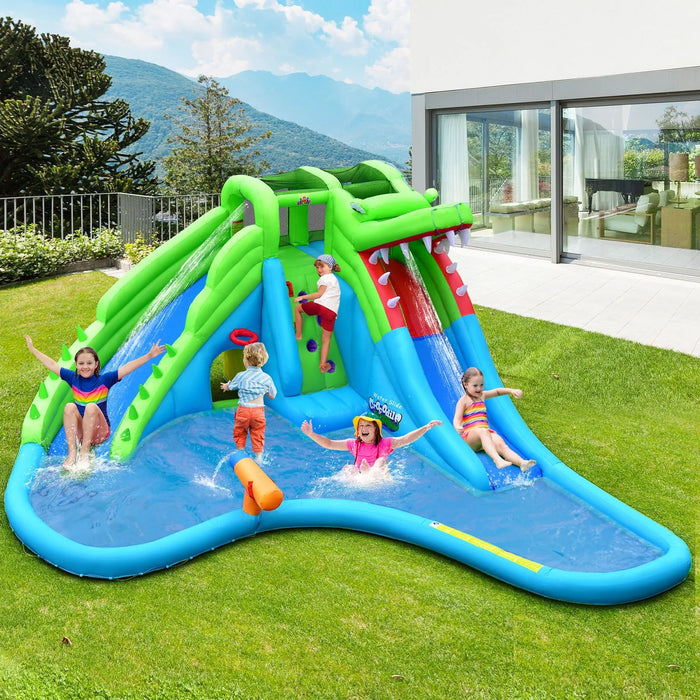 Giant green and blue inflatable bounce house water slide shaped like a crocodile with kids playing outdoors