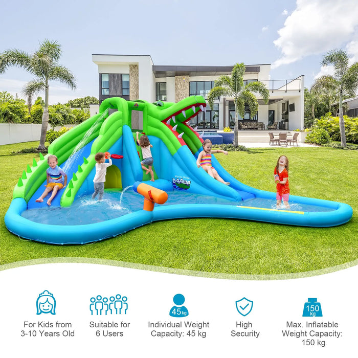 Children playing on a green and blue inflatable crocodile bounce house with water slides in a backyard
