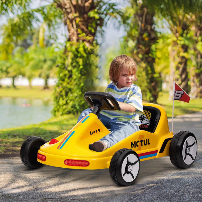 Child driving a yellow toy go-kart with a flag in a park setting