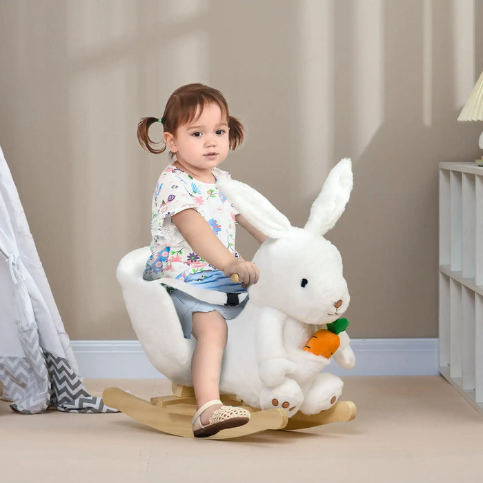 Child sitting on a white rabbit-shaped rocking toy in a room with neutral walls and a lamp.