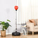 Red freestanding punching bag with black base in a modern living room with beige sofa and plant
