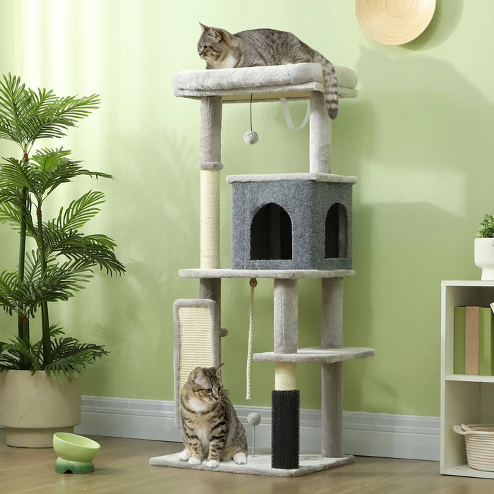 Two tabby cats on gray multi-level cat tree with scratching posts in cozy green room