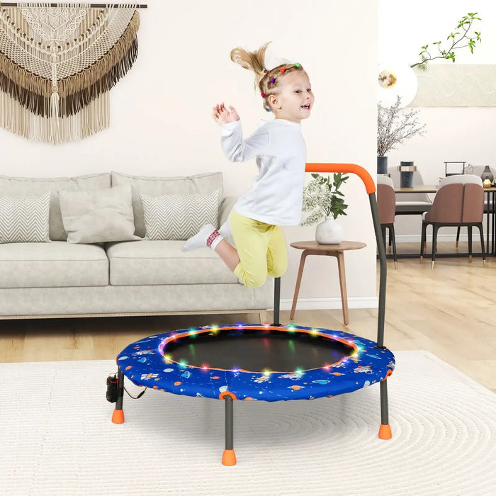 Child jumping on a small trampoline with colorful lights in a living room.