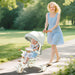Woman pushing a child in a stroller along a path in a park