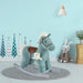 Blue plush rocking horse toy with saddle in a child's room with decorative trees and stuffed bunny