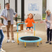 Child jumping on a small trampoline with two adults watching in a living room.