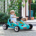 Child driving a toy car outdoors with greenery in the background