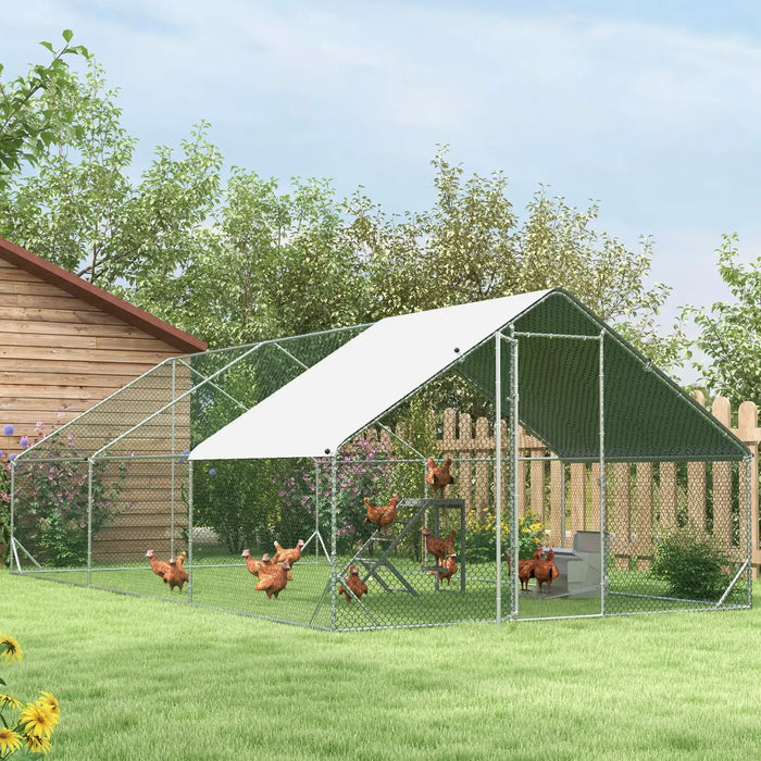 Outdoor chicken coop with metal frame, green wire mesh, white roof, and chickens inside in a garden