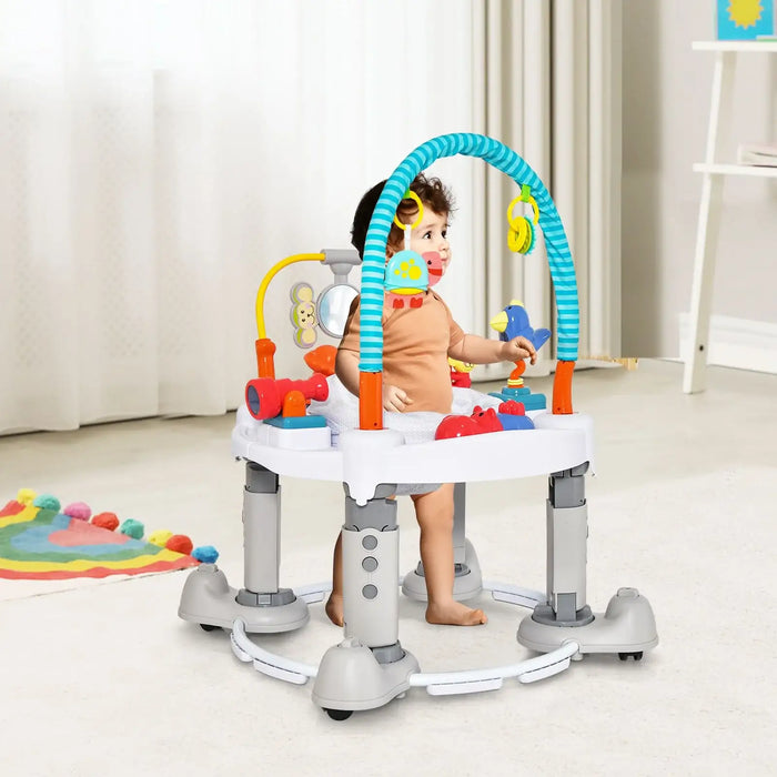 Toddler playing in a gray and white baby activity walker with colorful hanging toys in a bright room