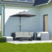 Outdoor patio set with a large umbrella on a patio area in front of a house.