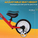 Kids' red balance bike with adjustable black seat height from 33 to 38 cm and training wheel